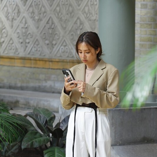 A woman using a safety app like bSafe or GeoSure on her smartphone.